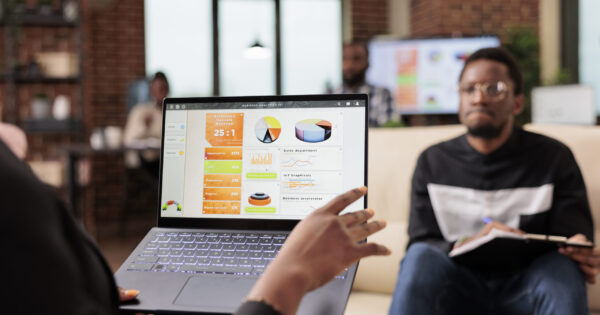 African american business people analyzing company charts African american business people analyzing company charts and diagrams on laptop to create startup presentation and paperwork report. Doing teamwork collaboration to plan research information.